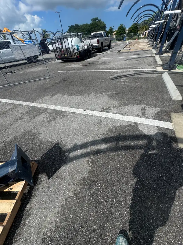 A truck and trailer parked on an asphalt lot, seen in a heavily shadowed side view.